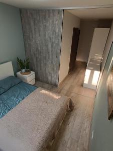a bedroom with a bed and a wooden floor at Lovely Stay in Siauliai in Šiauliai