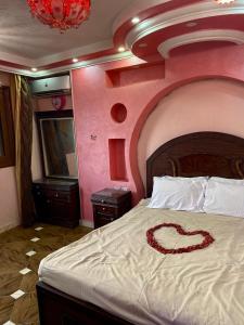 ein Schlafzimmer mit einem Bett mit einem Herz darauf in der Unterkunft Pyramids hills view apartment in Kairo