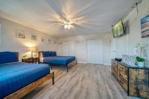 a bedroom with two beds and a ceiling fan at Camelot Beach Suites in Clearwater Beach