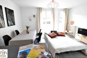 a living room with two beds and a table at La Halte temporaire Seh’Loué in Saint-Brieuc