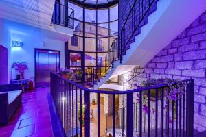 Hotel Antica Posada في Loceri: درج في منزل مع إضاءة أرجوانية