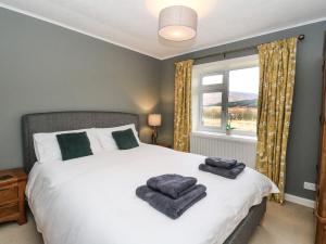 a bedroom with a bed with two towels on it at Ben Grianan in Aberfeldy