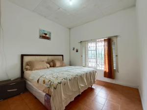 een slaapkamer met een bed en een raam bij Villa Cisarua Dongkris in Brujul