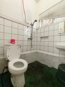 een badkamer met een wit toilet en een wastafel bij Villa Cisarua Dongkris in Brujul