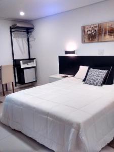 1 dormitorio con 1 cama blanca grande en una habitación en Pousada Jardim Paulista, en São Paulo