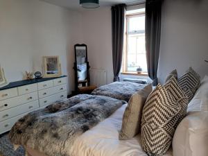 a bedroom with two beds and a dresser at The Apartment in Aberlour in Aberlour