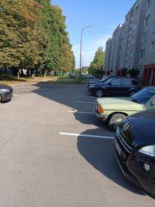a row of parked cars in a parking lot at Lovely Stay in Siauliai in Šiauliai