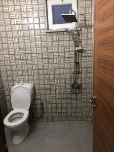 a bathroom with a toilet and a tile wall at Anamur Butik Otel in Anamur