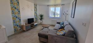 a living room with a couch and a tv at L'étape champenoise appartement in Bouy