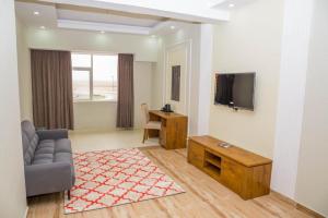 a living room with a couch and a tv on a wall at Itten Plaza Hotel 2 in Salalah