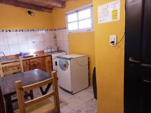 una pequeña cocina con mesa y nevera en Cabañas Los Nonos en El Bolsón