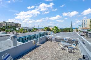 patio z krzesłami i stołem na dachu w obiekcie Camelot Beach Suites w mieście Clearwater Beach