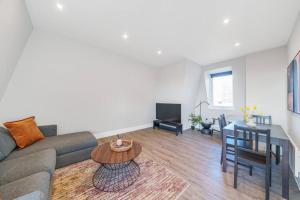 a living room with a couch and a table at Tranquil 2-Bed Oasis in Tooting 20 min to Central in London
