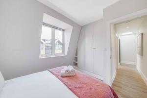 1 dormitorio con 1 cama con 2 toallas en Tranquil 2-Bed Oasis in Tooting 20 min to Central, en Londres