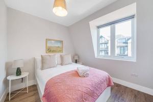 biała sypialnia z łóżkiem i oknem w obiekcie Tranquil 2-Bed Oasis in Tooting 20 min to Central w Londynie