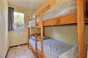 a bunk bed room with two bunk beds and a fan at Gite la Capelle Roquefort des Corbières Sigean Narbonne Aude in Roquefort-des-Corbières