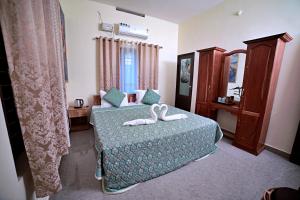 una camera da letto con un letto con due scarpe bianche di Gypsy Walker a Varkala