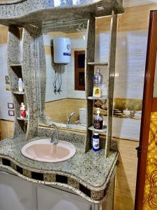 ein Bad mit einem Waschbecken und einem Spiegel in der Unterkunft Pyramids hills view apartment in Kairo