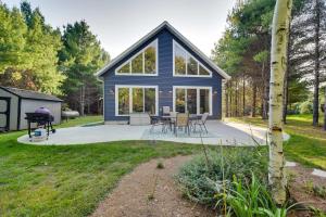 Cette maison bleue est dotée de baies vitrées et d'une terrasse. dans l'établissement Waterfront Webster Cabin with Dock on Warner Lake!, à Siren