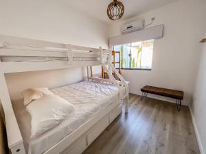 a bedroom with two bunk beds and a window at Casa Piscina Aquecida Canto Del Mare in São Sebastião