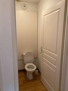 a bathroom with a white toilet and a door at Résidence L'Étoile d'Orion - Appartement au pied des pistes in Orcières