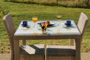 una mesa con un plato de comida y dos copas de vino en Hôtel La Bastide des Monges, en Nyons