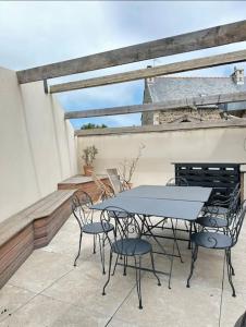 eine Terrasse mit einem Tisch und Stühlen auf dem Balkon in der Unterkunft Vents Marins in Saint-Quay-Portrieux
