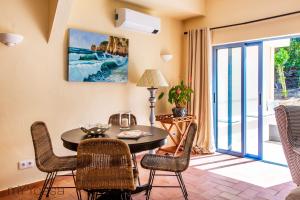 a dining room with a table and chairs and a balcony at Quinta Azul - Gorgeous Apartment with Pool & Private Terrace in Lagoa