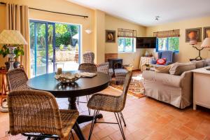 - un salon avec une table et des chaises dans l'établissement Quinta Azul - Gorgeous Apartment with Pool & Private Terrace, à Lagoa