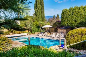 uma piscina num quintal com cadeiras e um guarda-sol em Quinta Azul - Gorgeous Apartment with Pool & Private Terrace em Lagoa