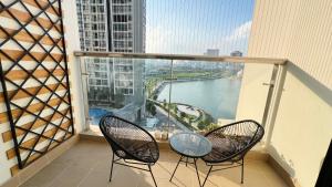 a balcony with two chairs and a view of a river at NanaHousing-Vinhomes Skylake-Luxury Apartment near Keangnam in Hanoi