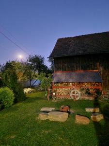 une cabane en rondins avec un chemin en pierre en face de celle-ci dans l'établissement Casa Hariton, à Drăguş