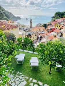 a group of white chairs sitting on top of a city at Albergo Degli Amici in Monterosso al Mare