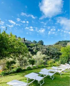 a row of white tables and chairs in the grass at Albergo Degli Amici in Monterosso al Mare