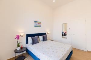 um quarto branco com uma cama com uma cabeceira azul em Blu Parthenope Suites em Nápoles