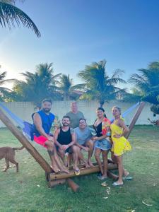 een groep mensen die op een picknicktafel op het strand zitten bij Casa Ferreira Cumbuco in Caucaia