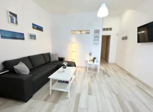 a living room with a black couch and a table at Cotillo Luna en centro, 1 min de la playa, cocina completa y WIFI in Cotillo