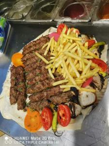 Bait Alaqaba dive center & resort في العقبة: طبق من الطعام مع البطاطس المقلية وشريحة لحم