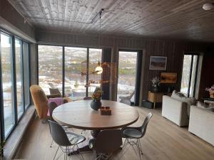 a living room with a table and chairs at Budalstølen-ny og flott hytte-sentral beliggenhet in Geilo