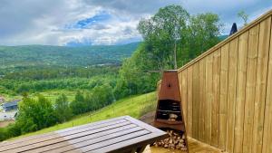 a wooden bench sitting next to a fence at Budalstølen-ny og flott hytte-sentral beliggenhet in Geilo