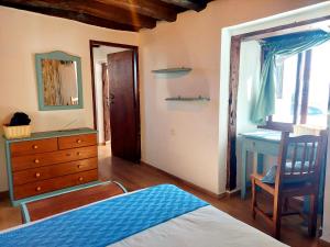 Schlafzimmer mit einem Bett, einer Kommode und einem Spiegel in der Unterkunft Casa Venus in Sabinosa