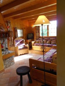 a living room with a lamp and a couch and a tv at La Ferme Des Favrays in Notre-Dame-de-Bellecombe