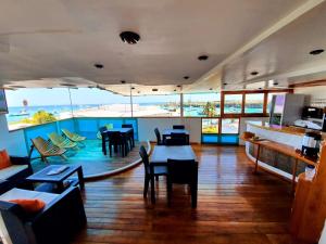 un restaurante con mesas y sillas y vistas al océano en Casa Ocean Pier en Puerto Ayora