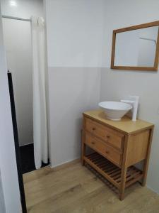 een badkamer met een wastafel en een spiegel op een dressoir bij Au gîte Sérénité in Mouthier-en-Bresse