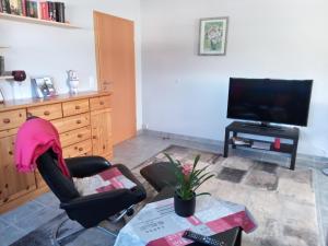 sala de estar con silla y TV en Ferienwohnung Bell im Brohltal, en Niederdürenbach