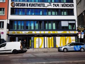 zwei vor einem Gebäude geparkt in der Unterkunft Design- und Kunsthotel München in München