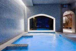 - une piscine d'eau bleue dans un bâtiment dans l'établissement hotel & spa Carré Saint-Louis, à Montréal