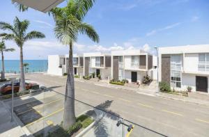 uma vista para uma rua com palmeiras e o oceano em Punta Blanca Beach Apartments Manta Coliving Ecuador em Jaramijó