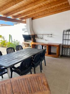 Una mesa y sillas de madera en un patio. en Villa One Tenerife, en Costa del Silencio