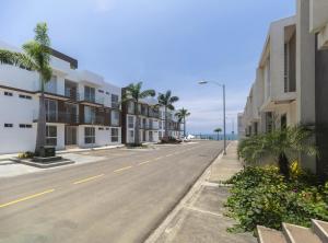 una calle vacía con edificios y el océano en Punta Blanca Beach Apartments Manta Coliving Ecuador en Jaramijó